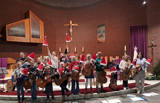 Leerlingen gitaar luisteren kerstviering op!